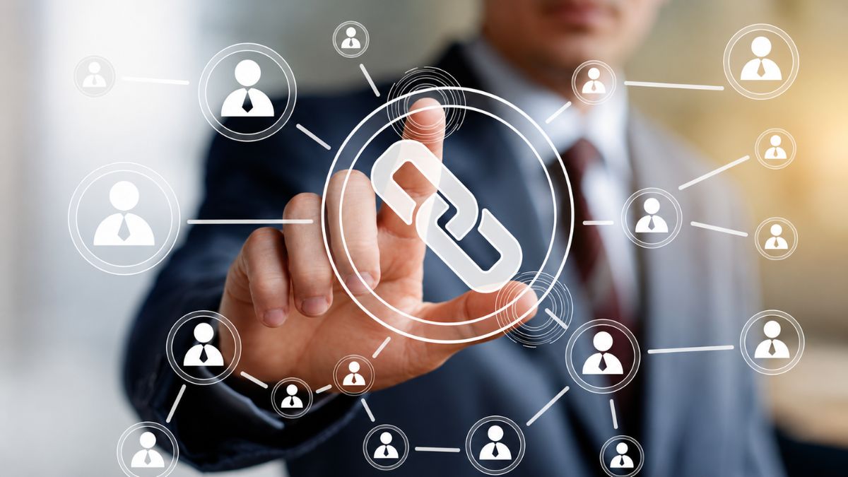 Profissional toca uma interface digital com ícone de corrente ao centro, cercado por conexões entre perfis, representando integração, networking e comunicação empresarial.
