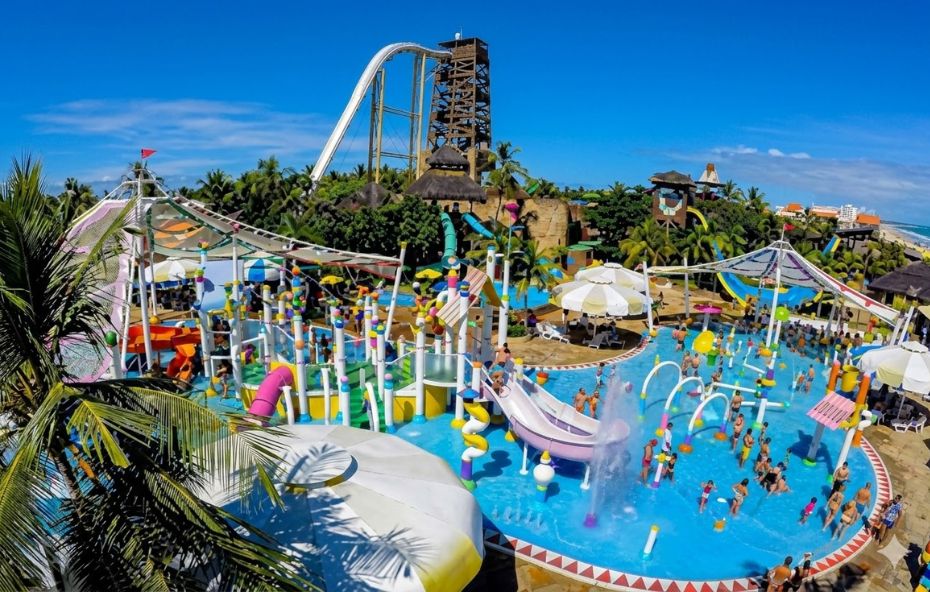 Foto aérea colorida de uma área de brinquedos aquáticos infantis no Beach Park Ceará Brasil onde se vê o famoso toboágua Insano ao fundo