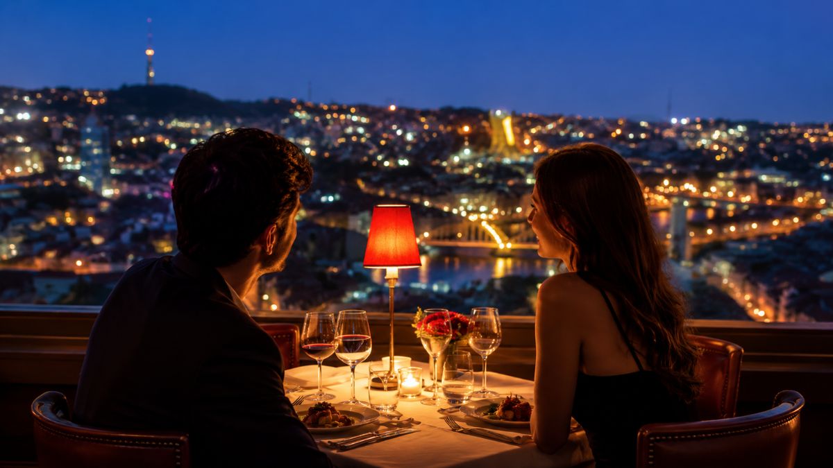 Casal desfrutando de um jantar romântico à luz de velas com vista noturna iluminada para a cidade do Porto em Portugal.